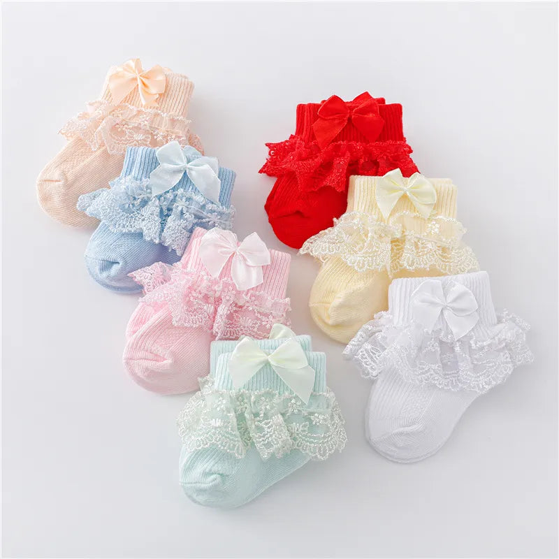 Close-up of a baby girl's lace sock featuring an elegant satin princess bow, newborn fashion accessory