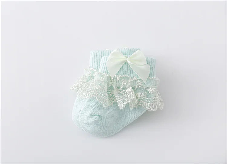 Top view of a pair of baby girl's lace socks with princess bows, infant footwear