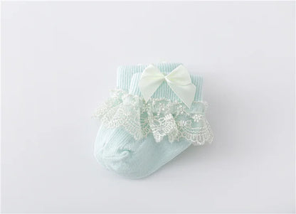 Top view of a pair of baby girl's lace socks with princess bows, infant footwear
