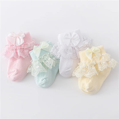 Pair of cute baby girl's white lace socks with detailed princess bows, ideal for newborns