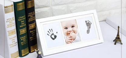 Display of a framed baby handprint and footprint created using the non-toxic ink pad kit