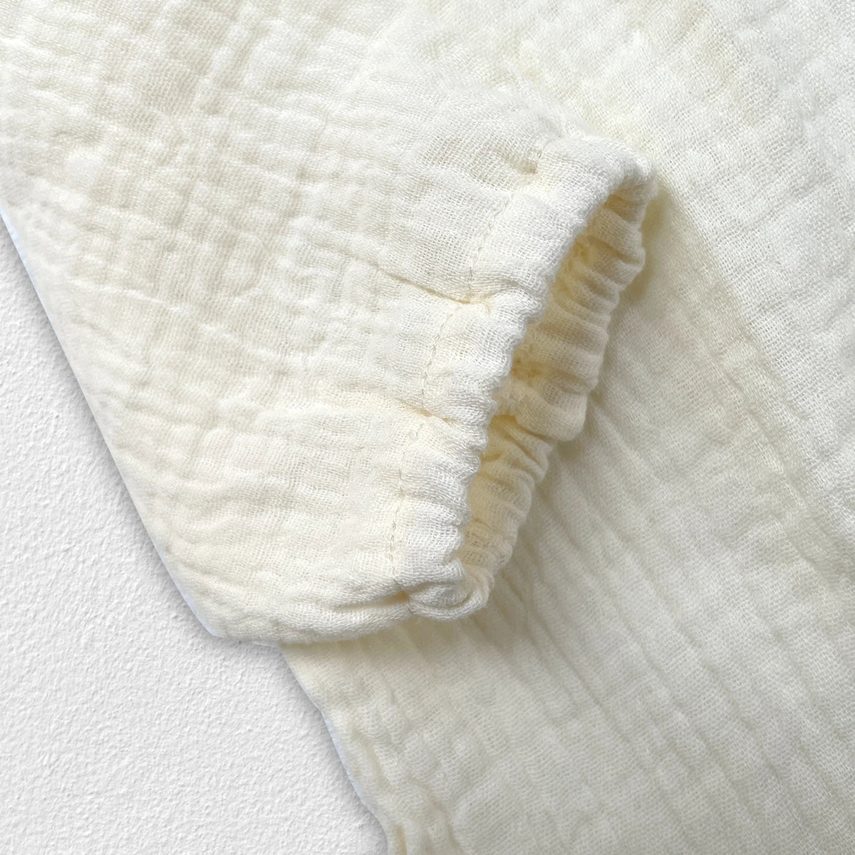 Overhead shot of newborn baby autumn clothing set, neutral colors, cotton fabric.