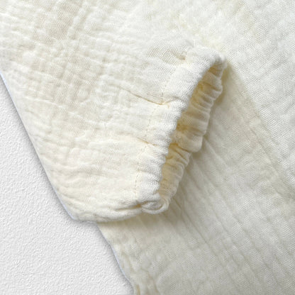 Overhead shot of newborn baby autumn clothing set, neutral colors, cotton fabric.