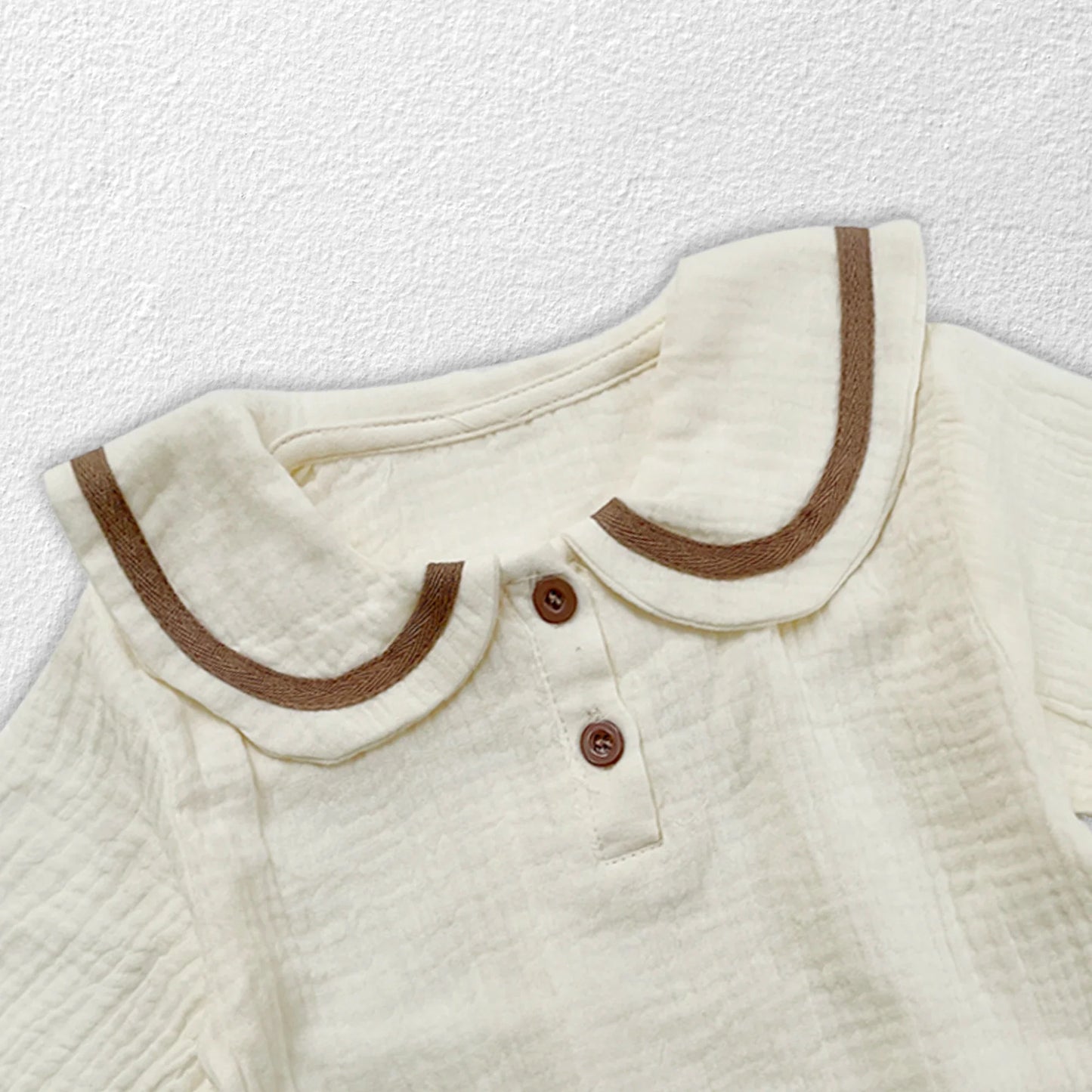 Close-up of cotton fabric on newborn autumn set, high-quality material for babywear.