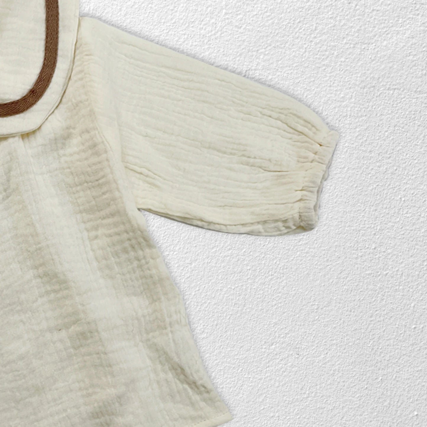 Newborn baby autumn clothing set in lifestyle shot, soft muted tones, infant style.