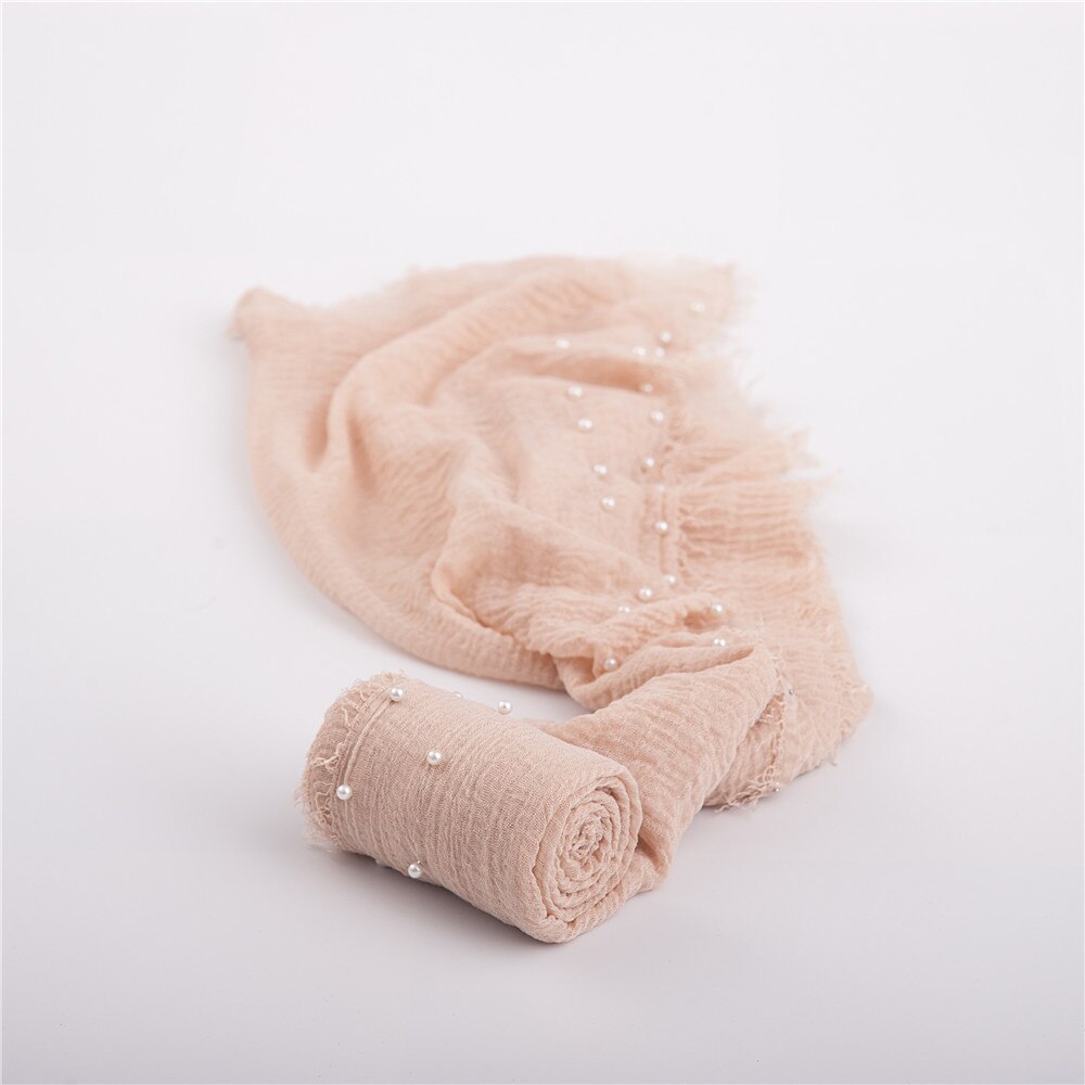 Detailed view of white beads on a soft cotton blend newborn baby swaddle blanket