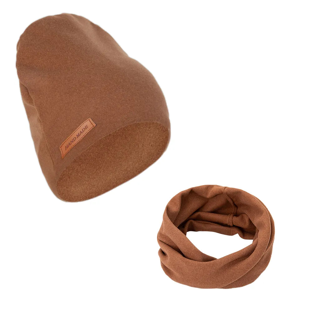 Newborn baby asleep wearing a gentle pink turban hat and scarf set, serene baby accessories.