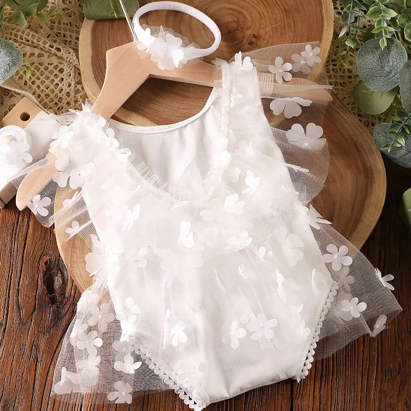 Beautiful newborn girl posing for a photo shoot in a bloom-print romper set