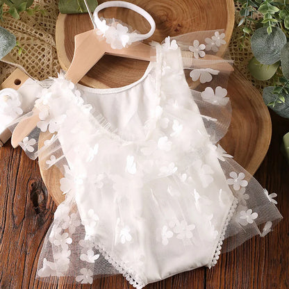 Beautiful newborn girl posing for a photo shoot in a bloom-print romper set