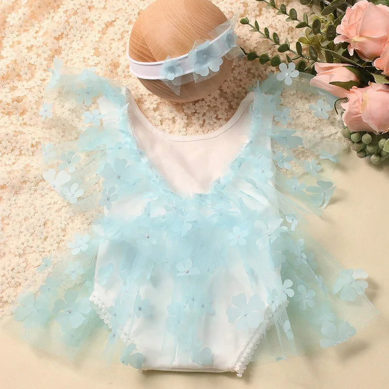 Top-down view of a newborn girl's floral romper and headband photography prop