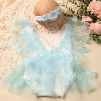 Top-down view of a newborn girl's floral romper and headband photography prop