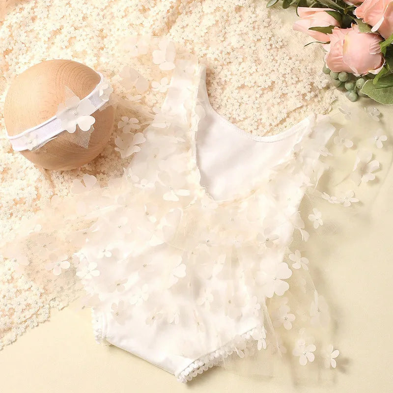 Styled flat lay of newborn baby girl floral outfit with prop accessories