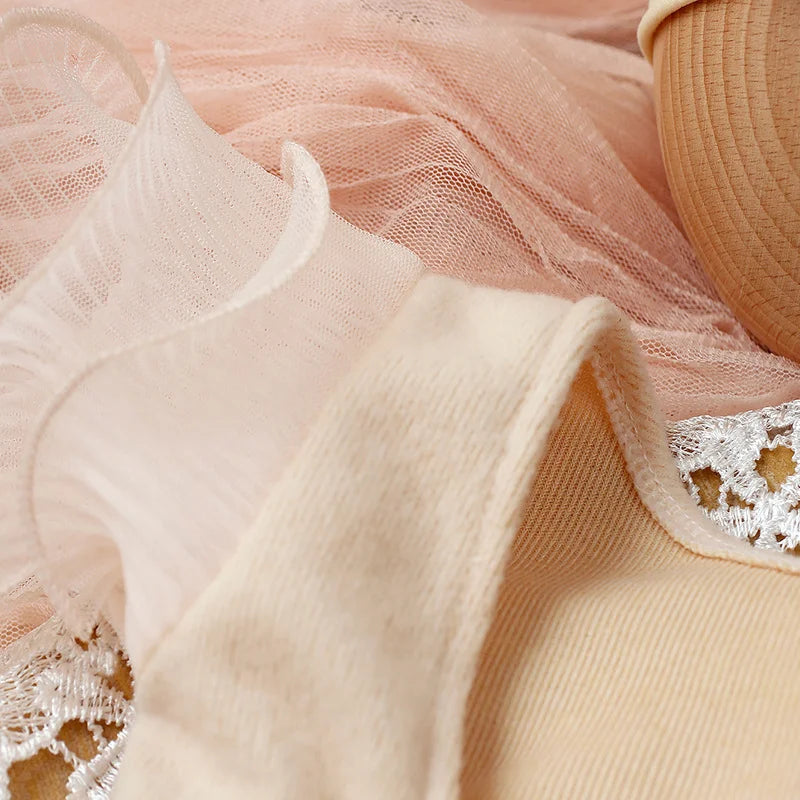 Detail shot of the lace fabric on the pink newborn girl romper, elegant and delicate design