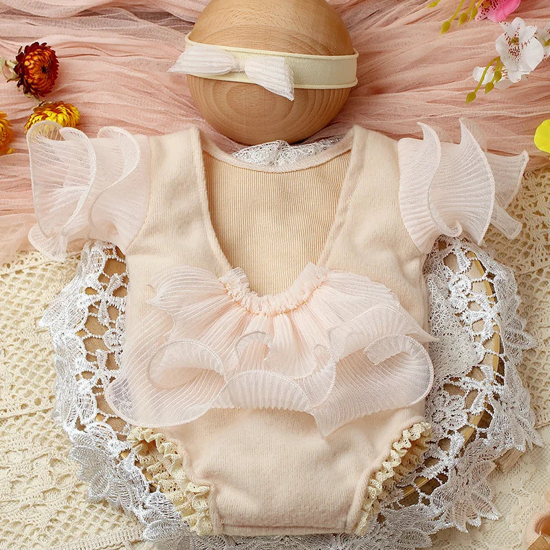 Soft pink lace romper for newborn girl with delicate bow headband, ideal baby photoshoot outfit