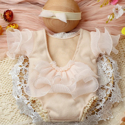 Soft pink lace romper for newborn girl with delicate bow headband, ideal baby photoshoot outfit