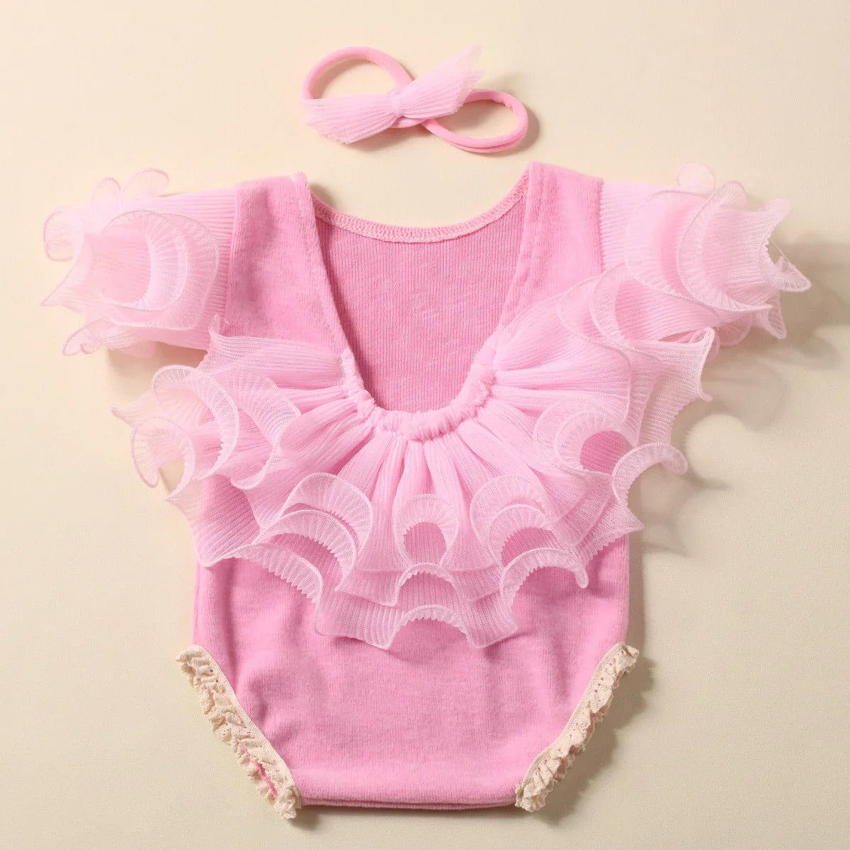 Baby girl in a lavender lace romper, featuring a soft fabric and elegant bow headband