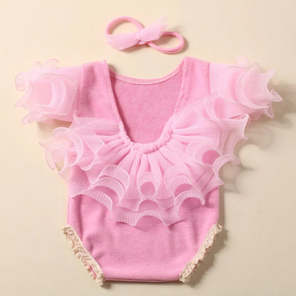 Baby girl in a lavender lace romper, featuring a soft fabric and elegant bow headband