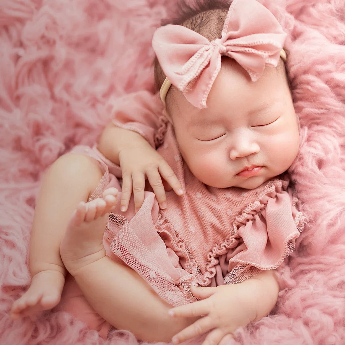 Light pink chiffon newborn romper and floral headband, a cute baby girl outfit for memorable photoshoots.