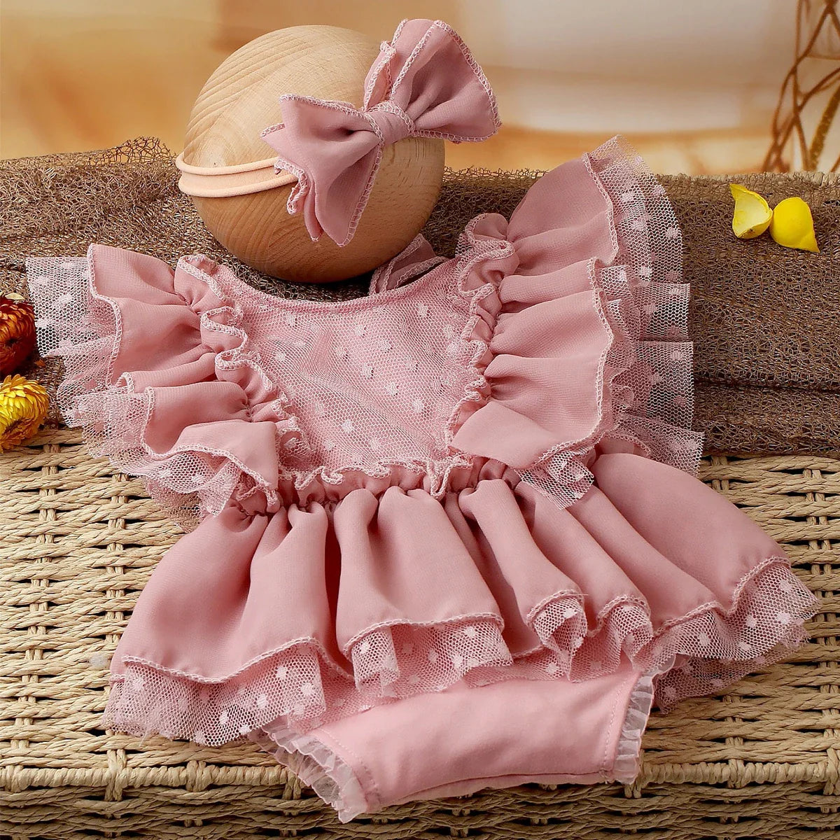 Soft light pink baby romper and coordinated headband, designed for newborn girl photography and infant wear.