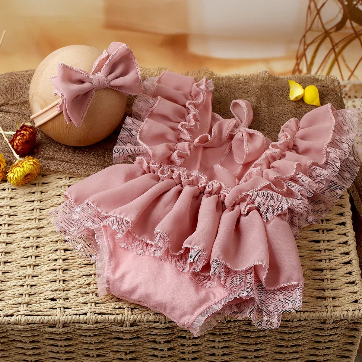 Chiffon light pink baby girl romper and delicate headband, a beautiful photo prop for newborn photoshoots.