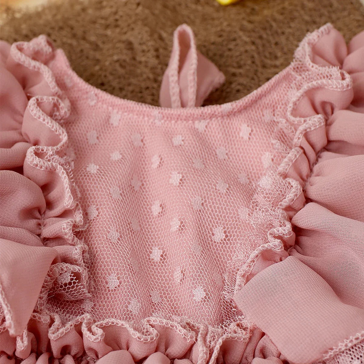 Baby girl fashion: light pink chiffon romper and charming headband, a sweet newborn photography outfit.