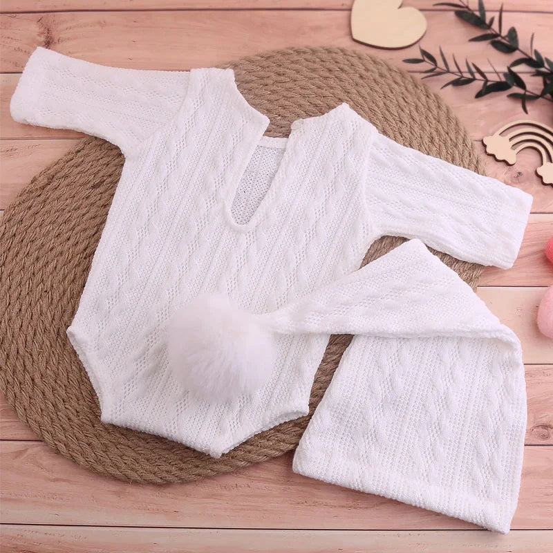Full view of unisex baby knit jumpsuit and fluffy pompom hat for photography