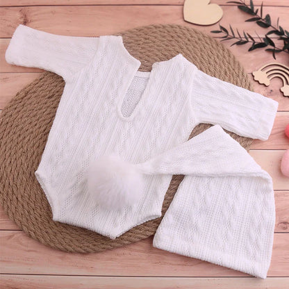 Full view of unisex baby knit jumpsuit and fluffy pompom hat for photography