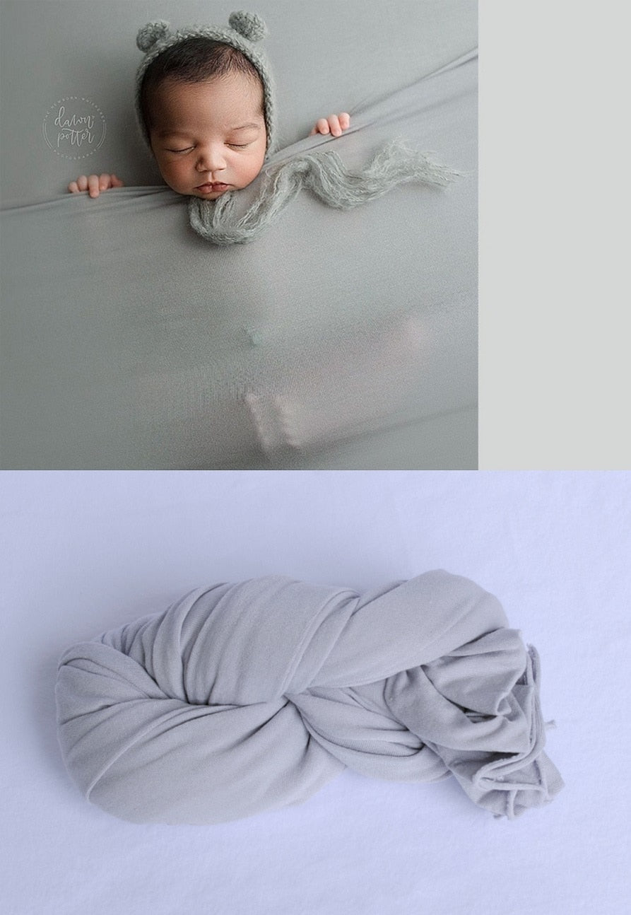 Cute newborn snuggly wrapped in a cotton swaddle blanket, a perfect baby photography prop.