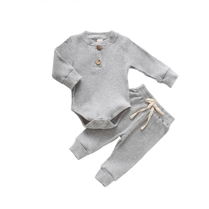 Adorable unisex newborn ribbed bodysuit in plaid, paired with solid elastic pants.