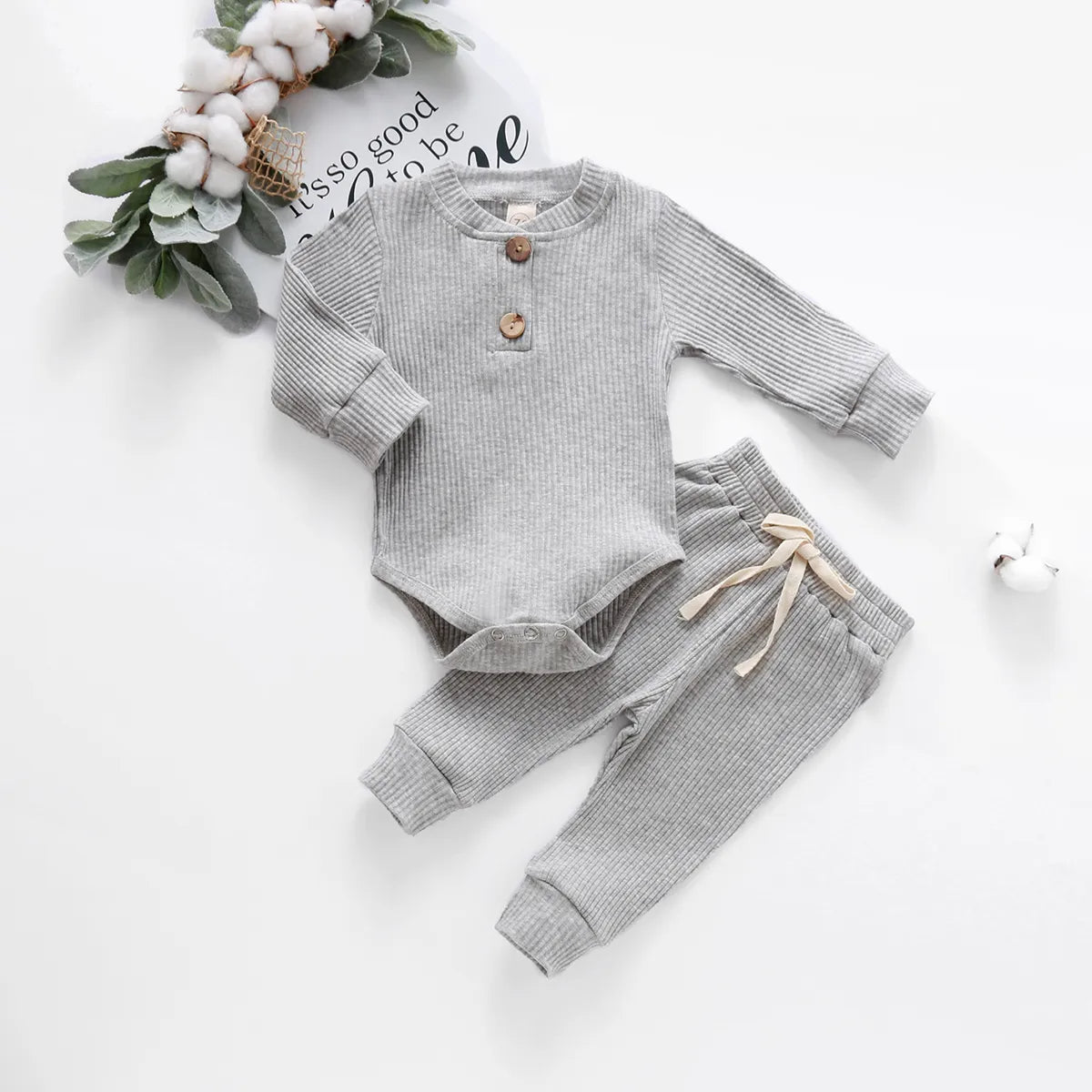 Full view of an infant in a cozy unisex ribbed plaid bodysuit and comfortable pants.