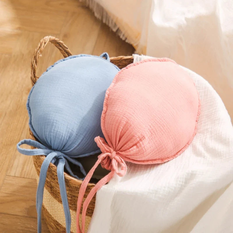 White Nordic balloon baby pillow standing upright, illustrating its unique shape for nursery