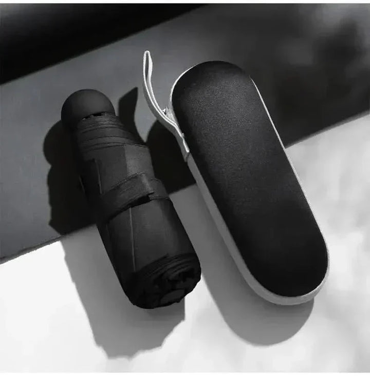 Sleek, closed ultra-compact travel umbrella in its stylish capsule design. Perfect portable rain accessory.