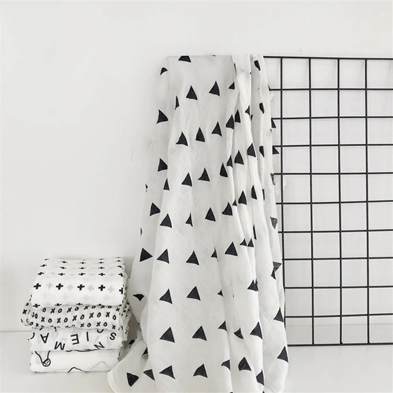 Baby comfortably wrapped in a neutral organic muslin swaddle blanket for deep, restful sleep