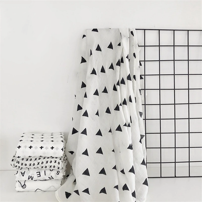 Baby comfortably wrapped in a neutral organic muslin swaddle blanket for deep, restful sleep