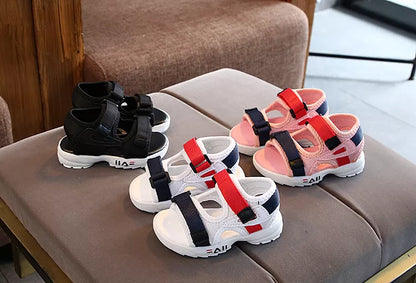 Child running in pink slip-on sport sandals on grass, showcasing durability and anti-slip feature.