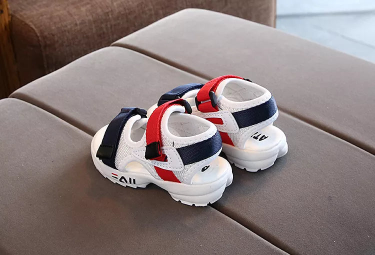 Toddler's feet in green soft sole sport sandals, standing by a pool, anti-slip for wet surfaces.
