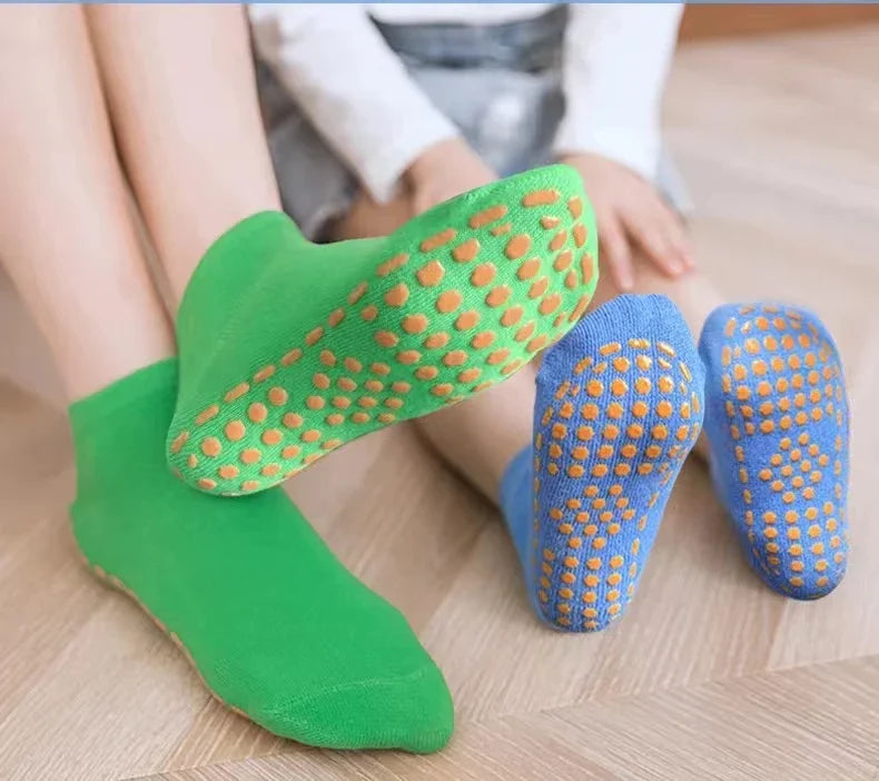 Family wearing matching anti-slip cotton trampoline socks for indoor play.