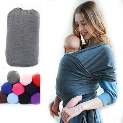 Parent wearing a gray baby wrap carrier, newborn nestled ergonomically, hands-free.