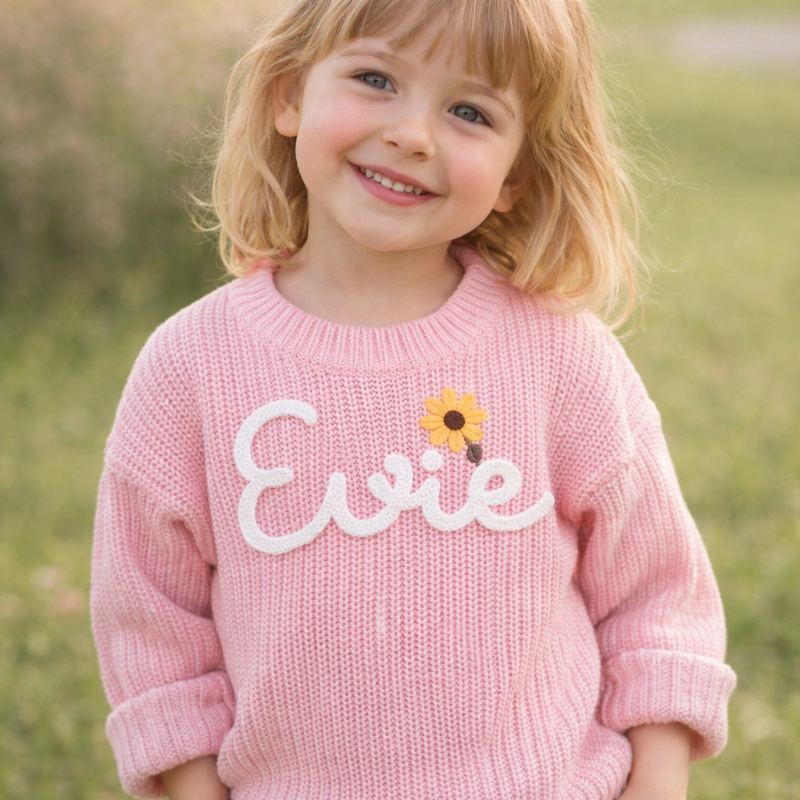 Custom embroidered knit top for toddlers, 'Liam' name in blue, cozy cotton blend material.