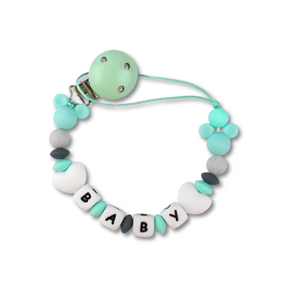 Detail shot of a personalized pacifier clip with 'Jacob' name on a wooden bead.