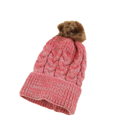 Top-down view of a personalized knit toddler hat with a fluffy white pom pom