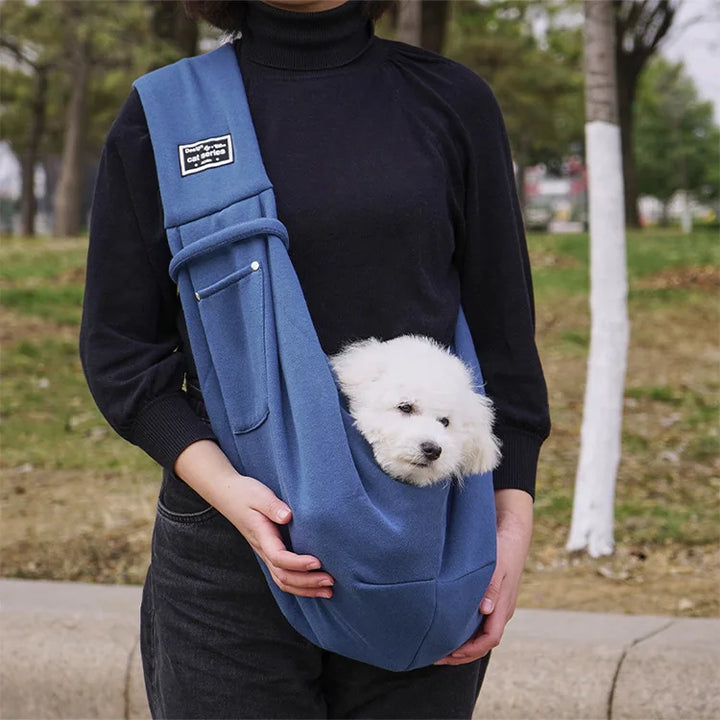 Lightweight pet travel sling for small dogs & cats. Features secure buckle and soft padding for pet comfort.