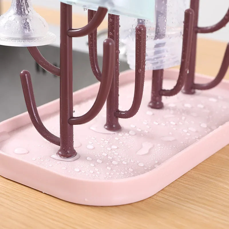 Beige baby bottle drying rack with pacifiers and bottle brushes, a practical feeding accessory.