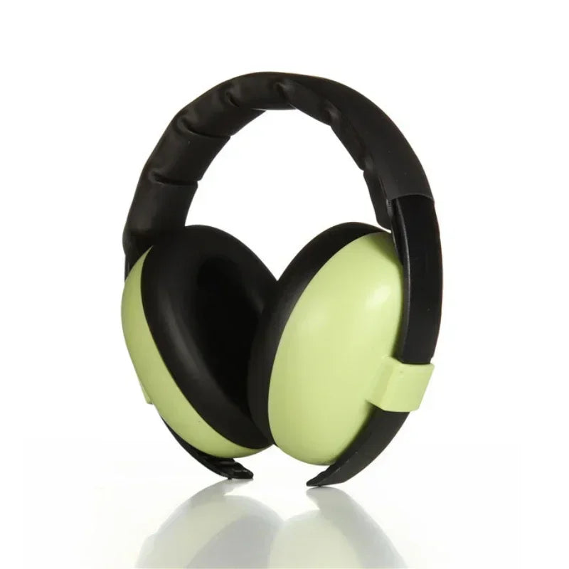 Pink baby noise-canceling earmuffs on a wooden surface, ready for infant and toddler use, adjustable.