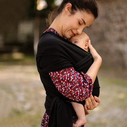 Pink ergonomic baby carrier sling for comfortable, hands-free infant carrying, perfect for new parents.