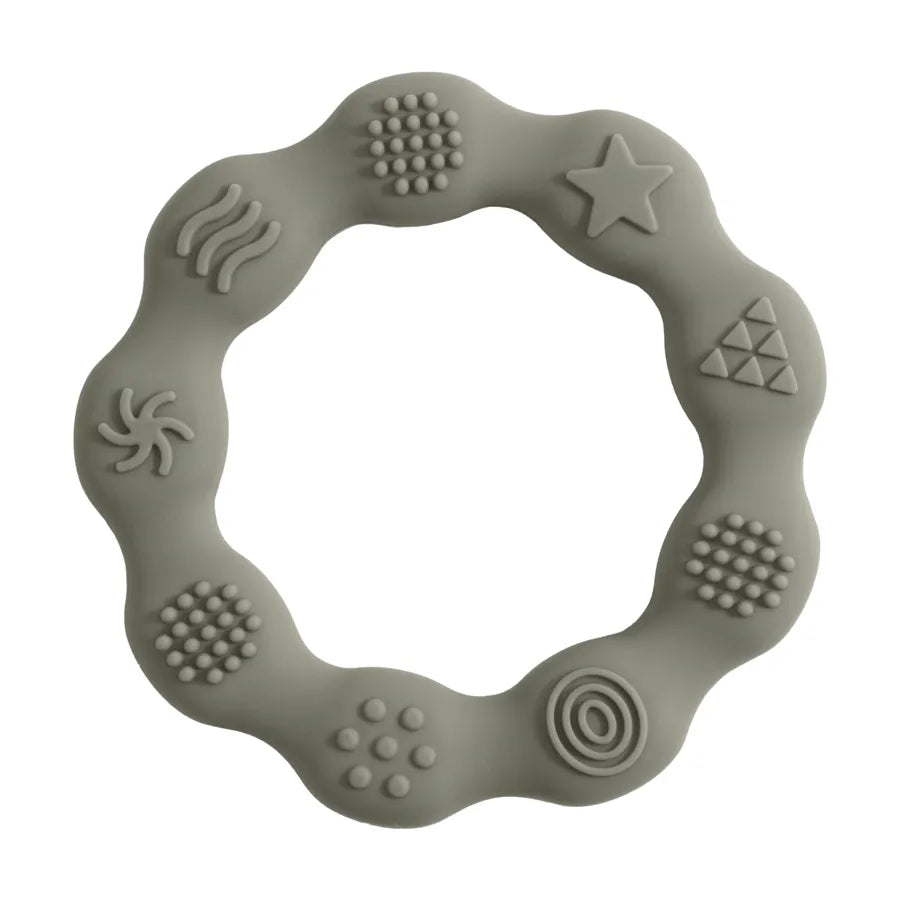 Baby playing with a star-shaped green silicone teether, BPA-free, for soothing relief