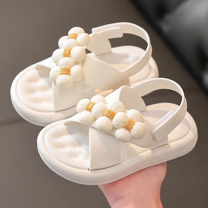 Black girls' platform sandals featuring floral decor, comfortable slip-on kids' flats.