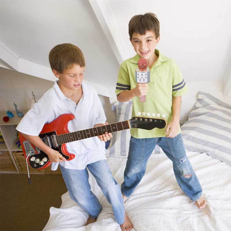 Group of kids laughing and singing with wireless Bluetooth karaoke microphones
