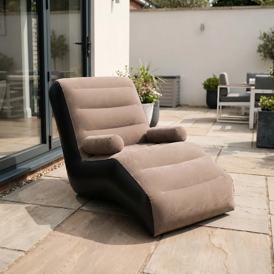 Pink S-shaped inflatable lounger for garden patio relaxation, comfortable portable outdoor furniture.