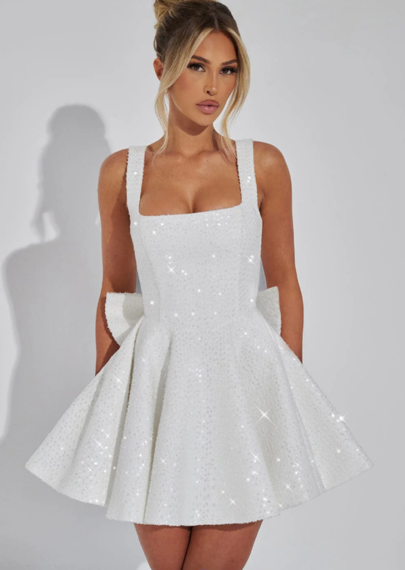 Women's white sequin mini dress with bow, ideal for homecoming, dance, & special occasions.